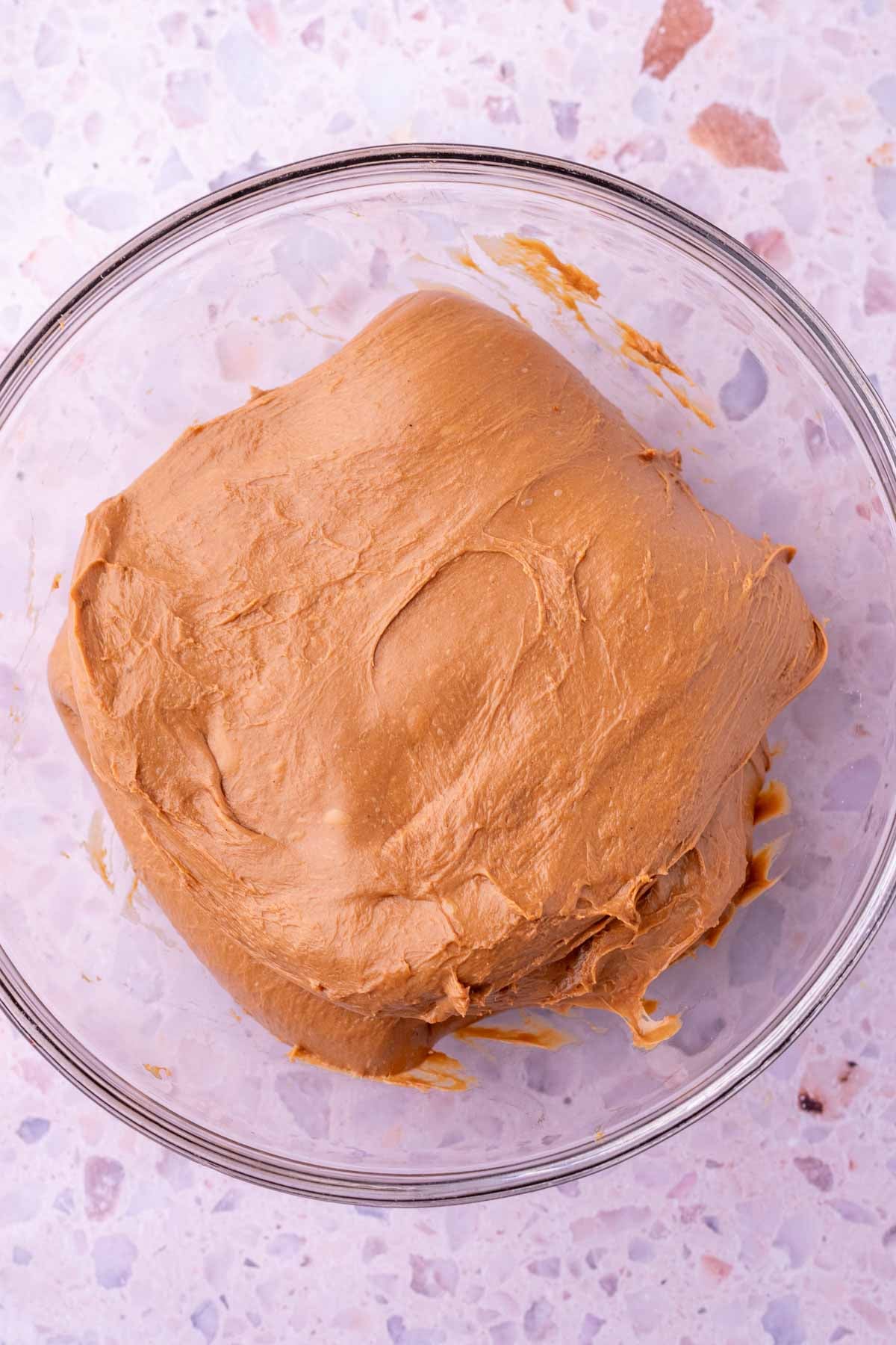 Sourdough chocolate brioche dough in a glass bowl at the start of bulk fermentation.