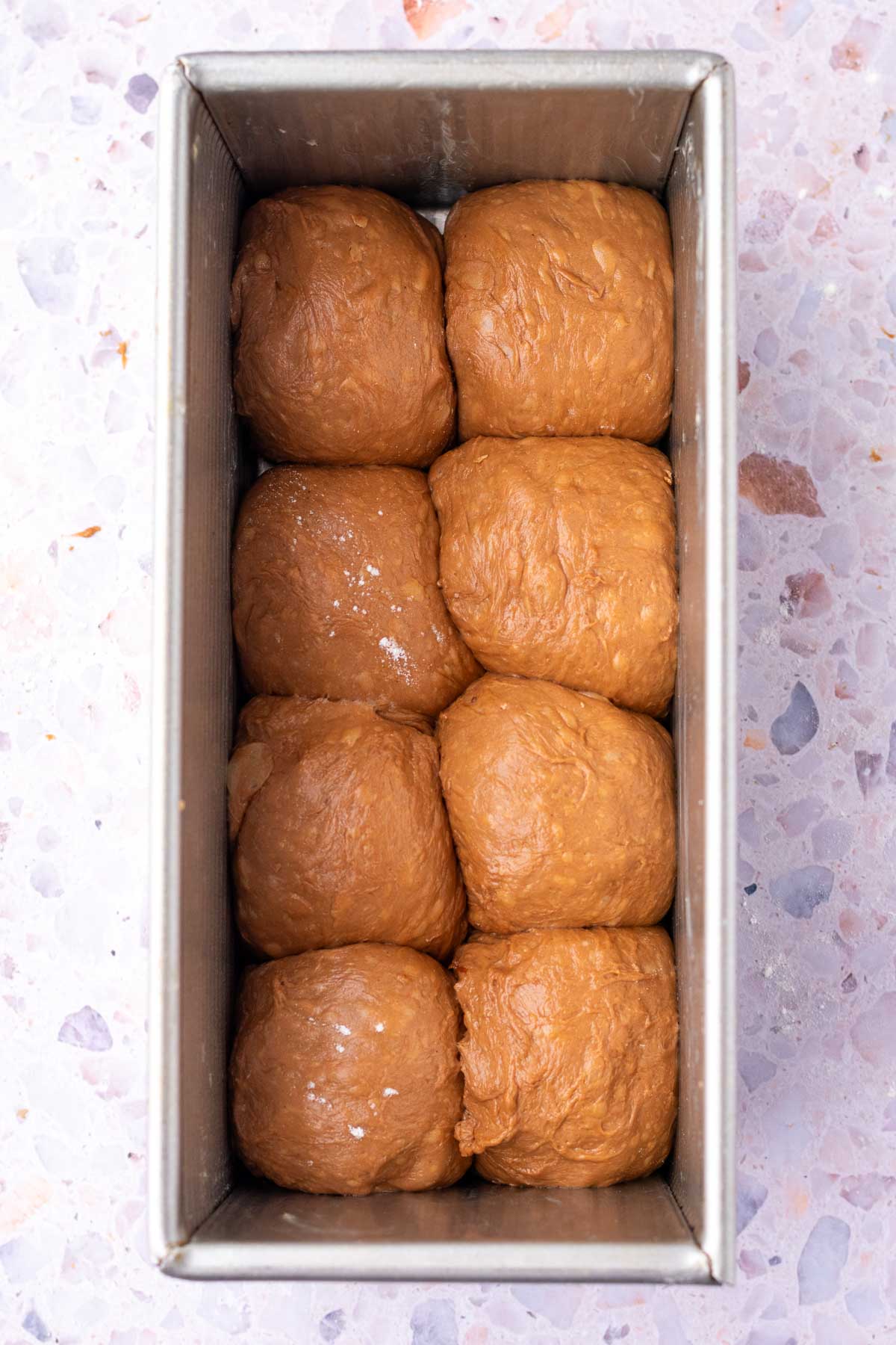 Sourdough chocolate brioche balls in a bread loaf pan at the start of final proofing.