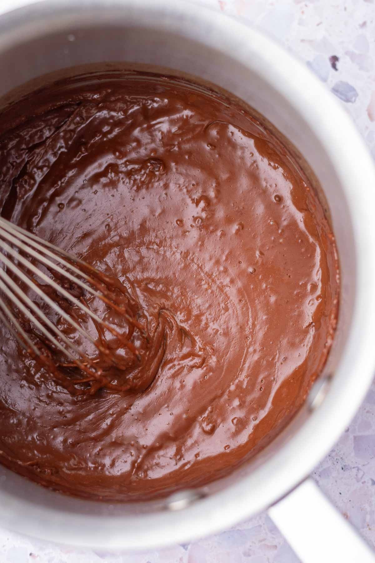 Whisking chocolate tangzhong for sourdough chocolate brioche dough in a saucepan with a whisk.