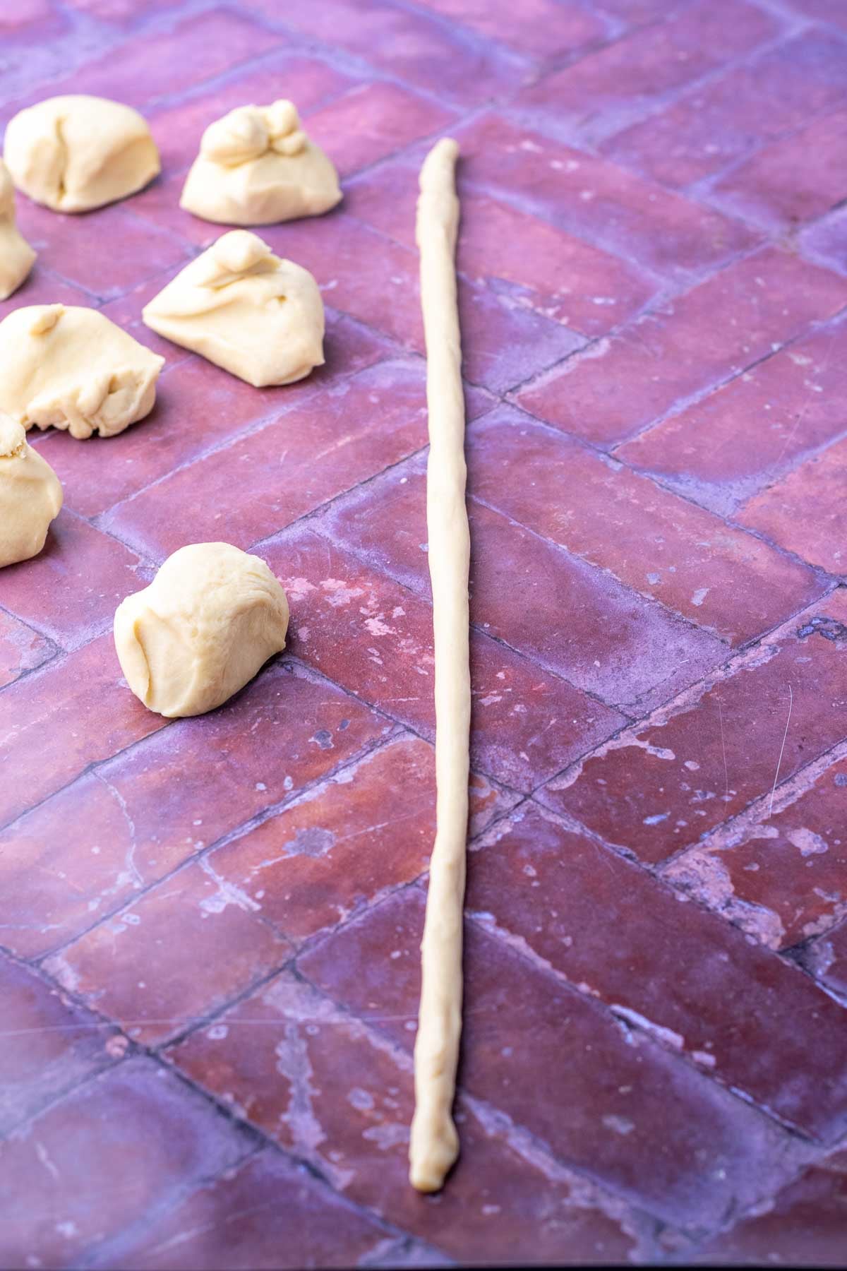 Long rope of sourdough brioche dough for shaping sourdough pigs in a blanket.