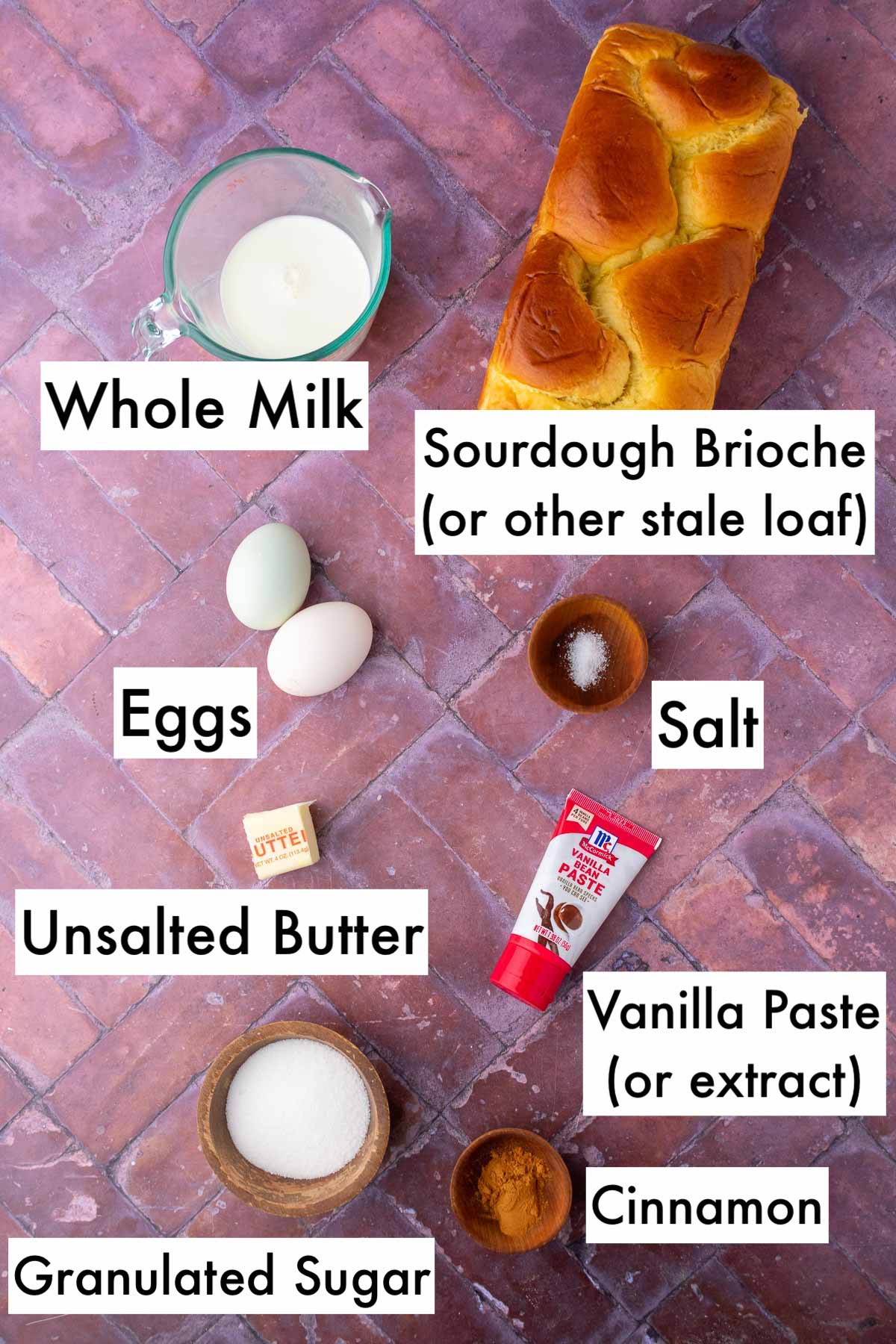 Labeled ingredients needed for sourdough cinnamon french toast sticks including sourdough brioche, whole milk, eggs, salt, unsalted butter, vanilla, granulated sugar, and cinnamon.