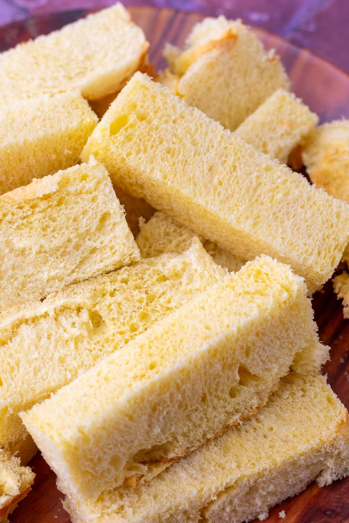 Sliced sourdough brioche bread into batons for french toast sticks.