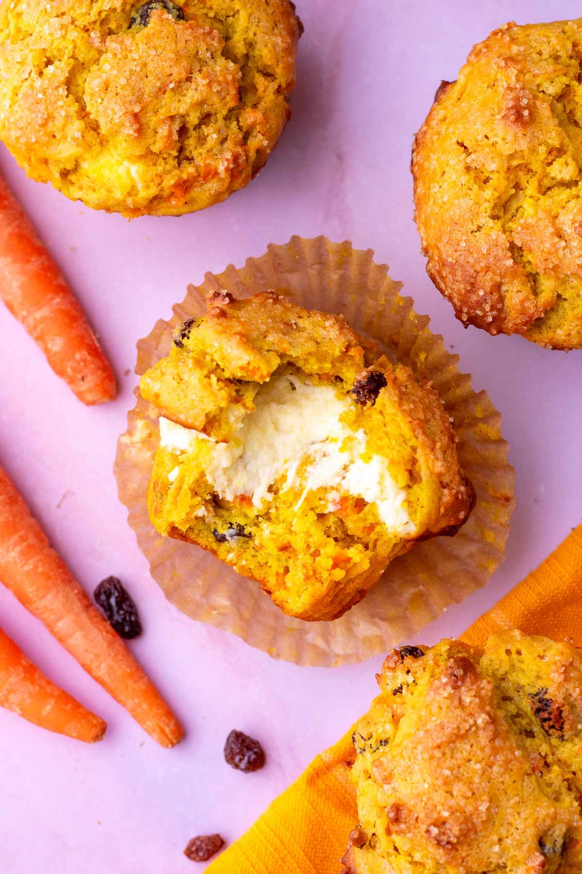 Bite taken out of a sourdough carrot cake muffin with cream cheese filling.