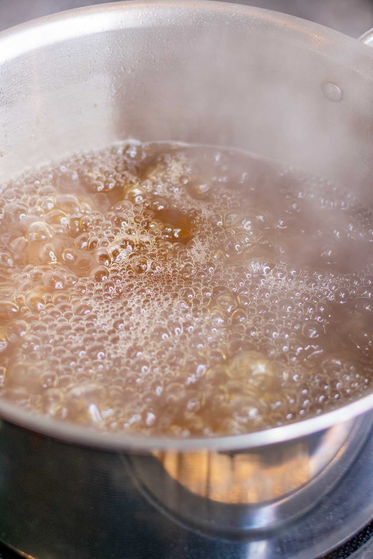 Boiling maple sap into syrup in a large pot.