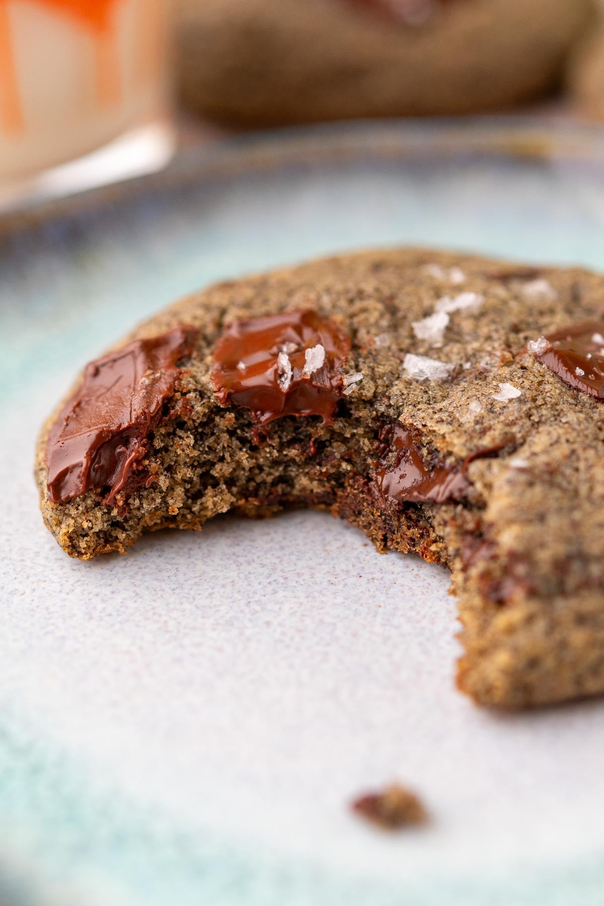 Close up of a bite of a gooey sourdough buckwheat chocolate chip cookie.