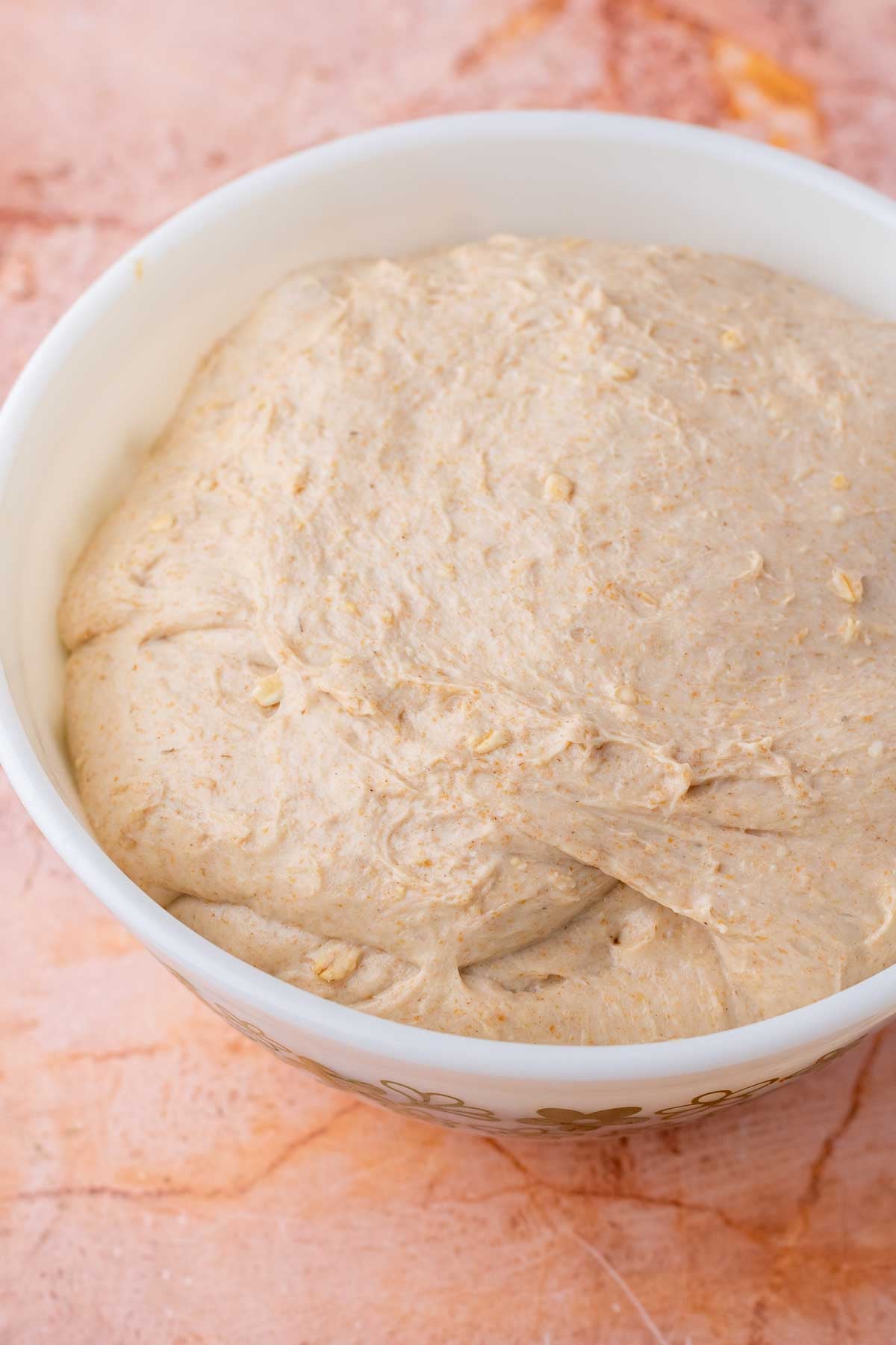 Bowl of dough from maple oat sourdough sandwich bread at the end of bulk fermentation.