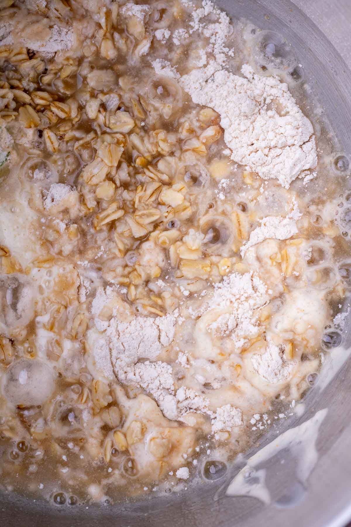 Start of mixing maple oat sourdough sandwich bread in bowl with maple oat porridge.