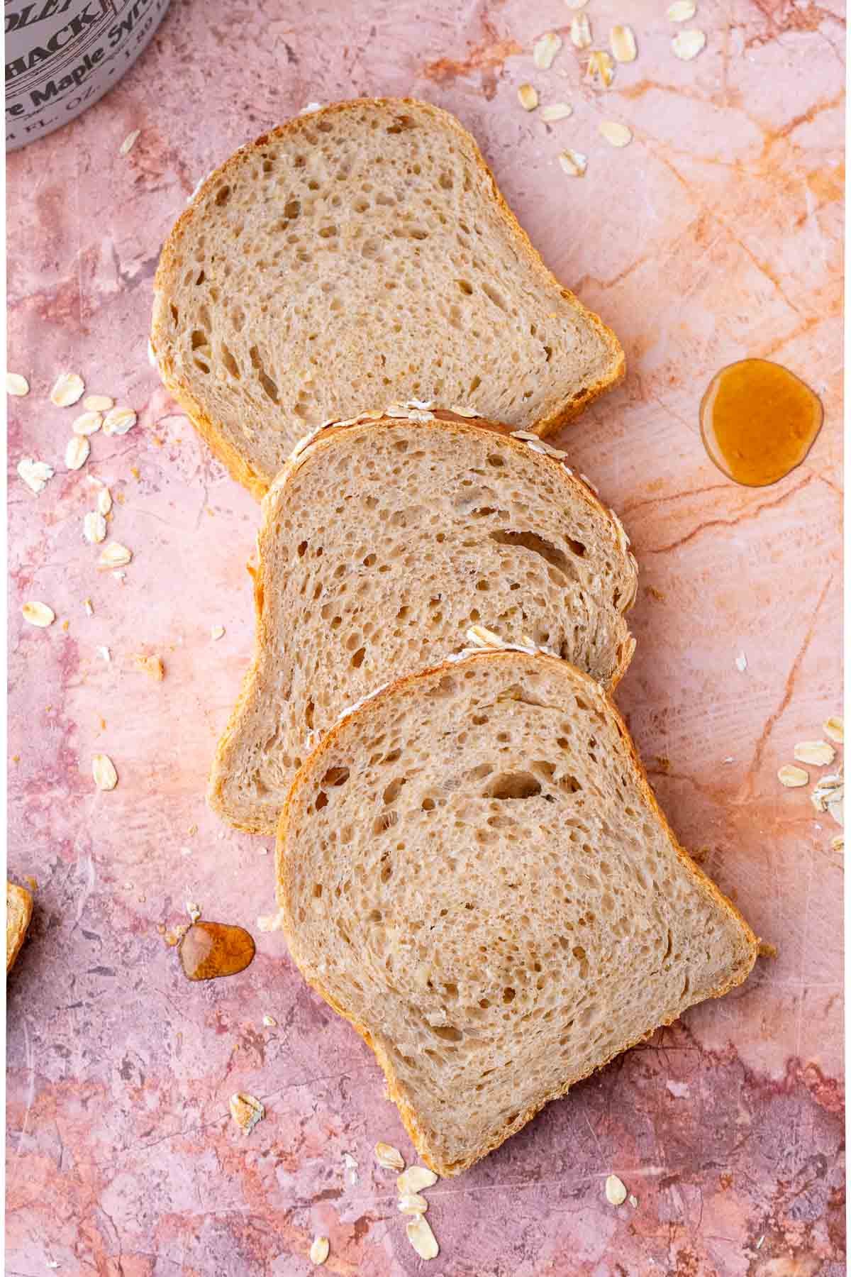 Three slices of maple oat sourdough sandwich bread.