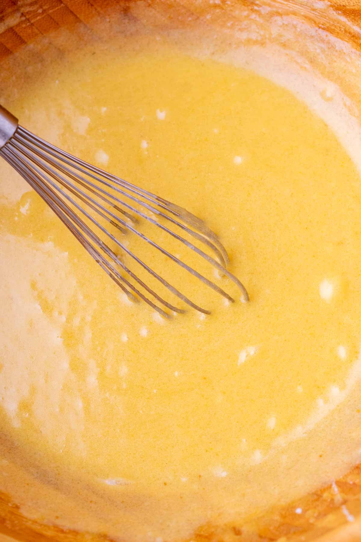 Whisking wet ingredients for sourdough buckwheat chocolate chip cookies in a bowl.