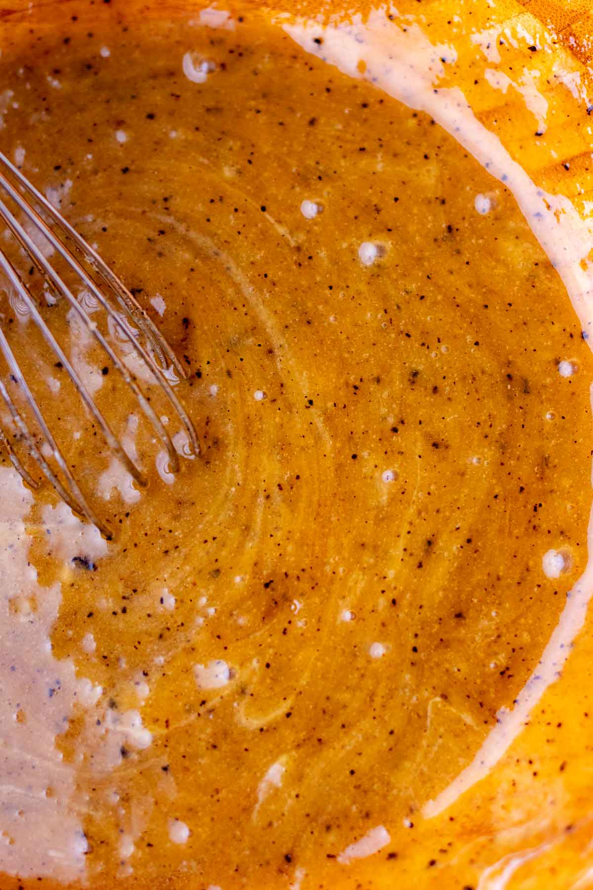 Wet ingredients mixed for sourdough rye chocolate chip cookies in a bowl with a whisk.