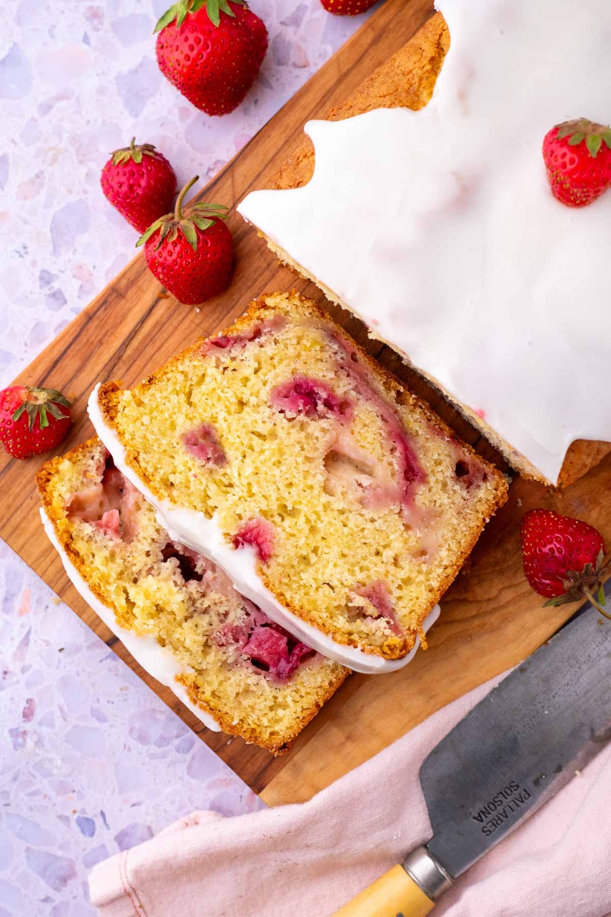 Slicing Sourdough Strawberry Bread on a cutting board.