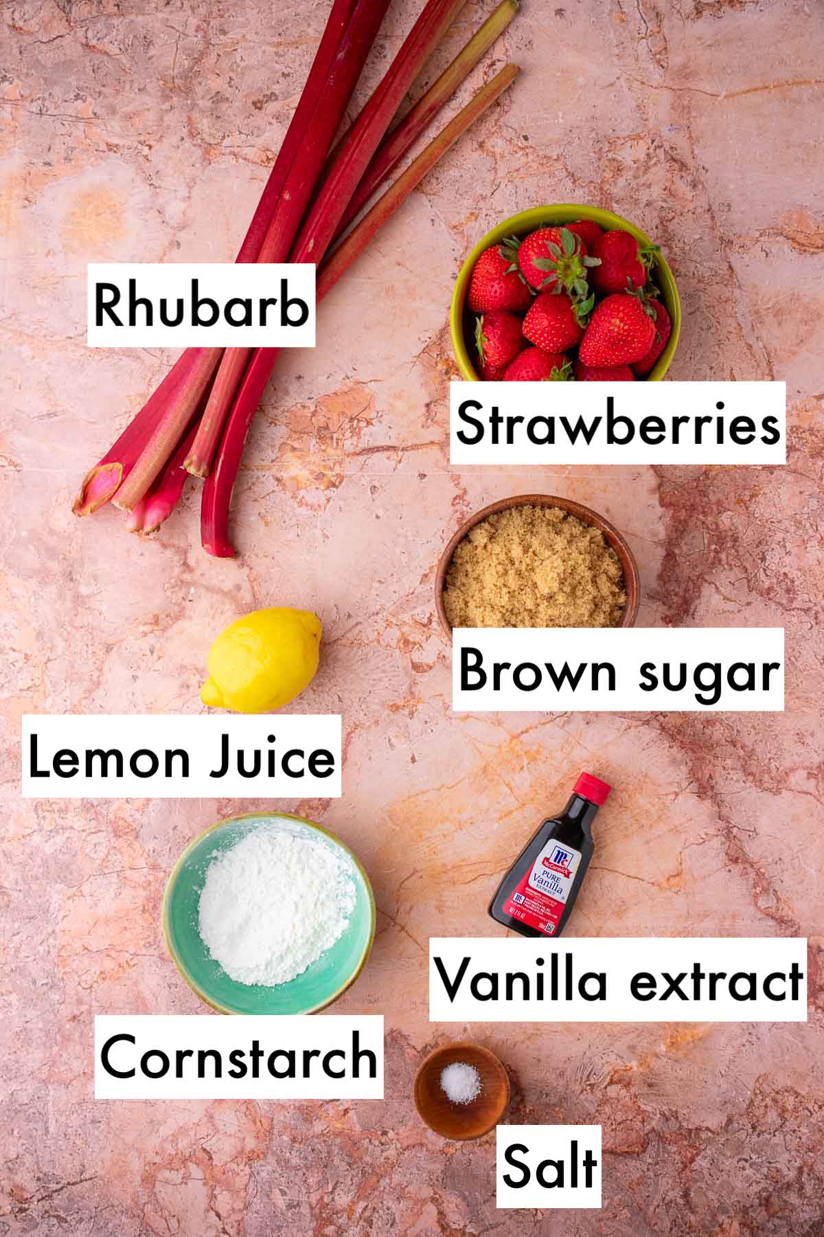 Labeled ingredients needed for sourdough strawberry rhubarb pie including rhubarb, strawberries, lemon juice, brown sugar, cornstarch, vanilla extract, and salt.