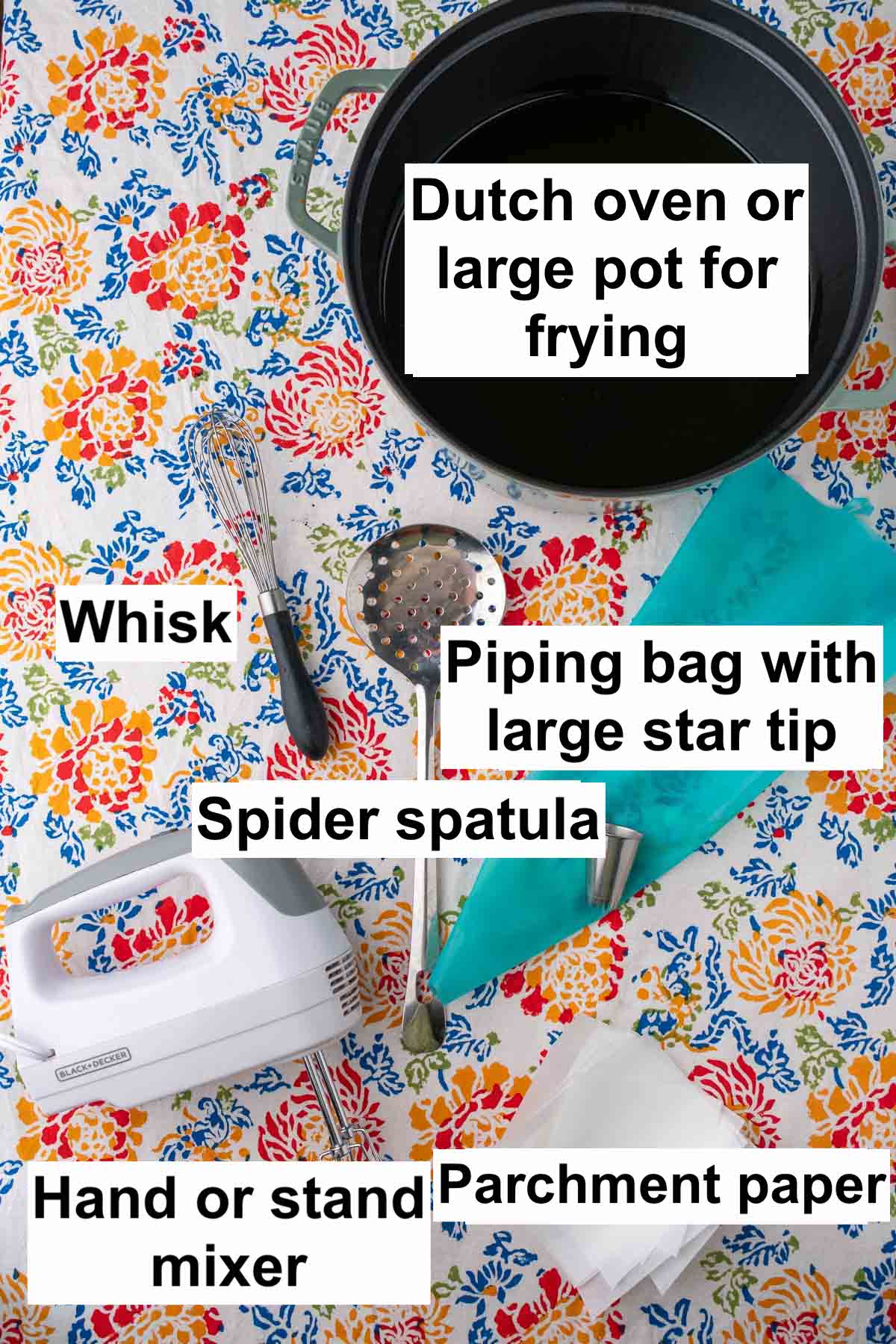 Tools needed for sourdough crullers including a dutch oven, whisk, spider spatula, piping bag with large star tip, electric hand mixer, and parchment paper.