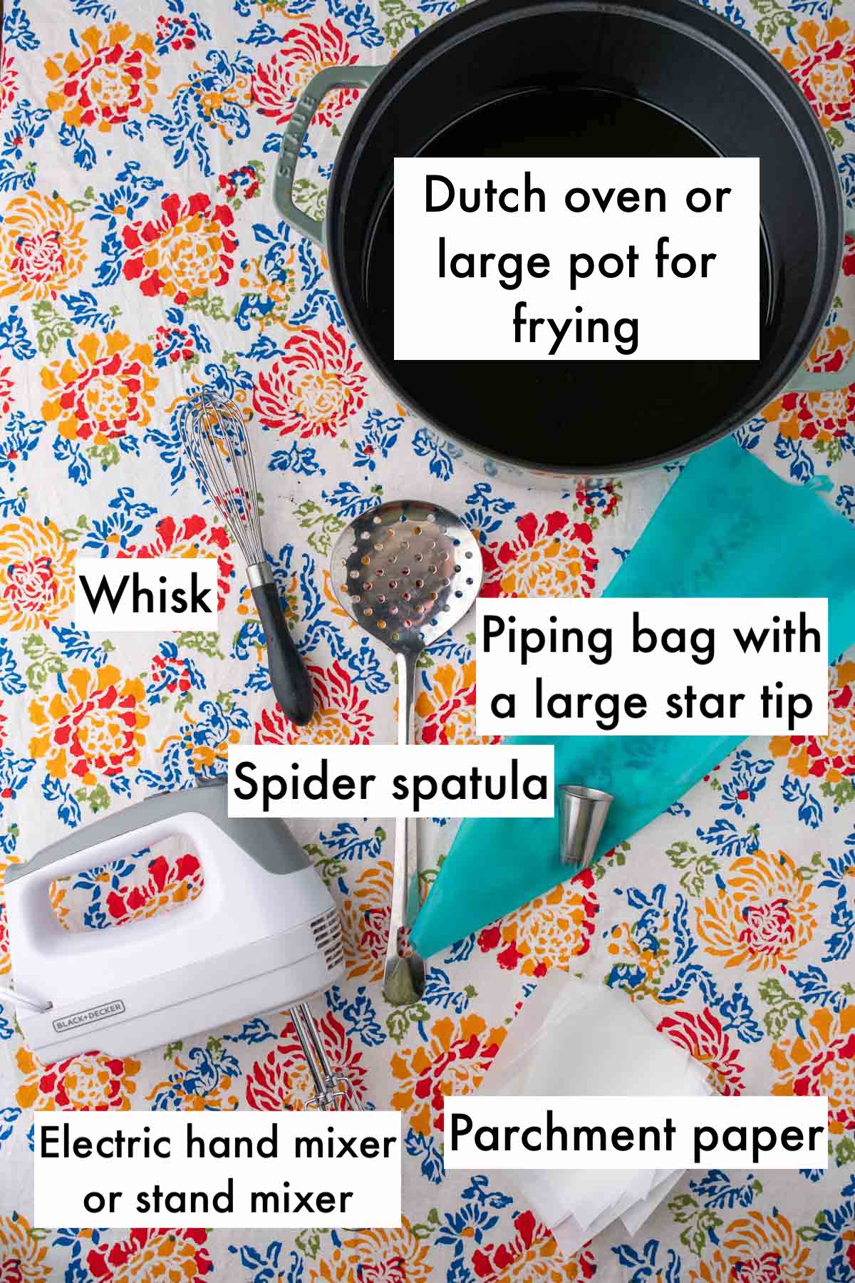 Tools needed for sourdough crullers including a dutch oven, whisk, spider spatula, piping bag with large star tip, electric hand mixer, and parchment paper.