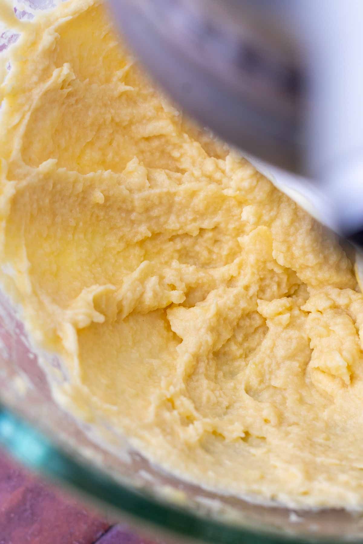 Creaming butter and honey together in a stand mixer bowl.