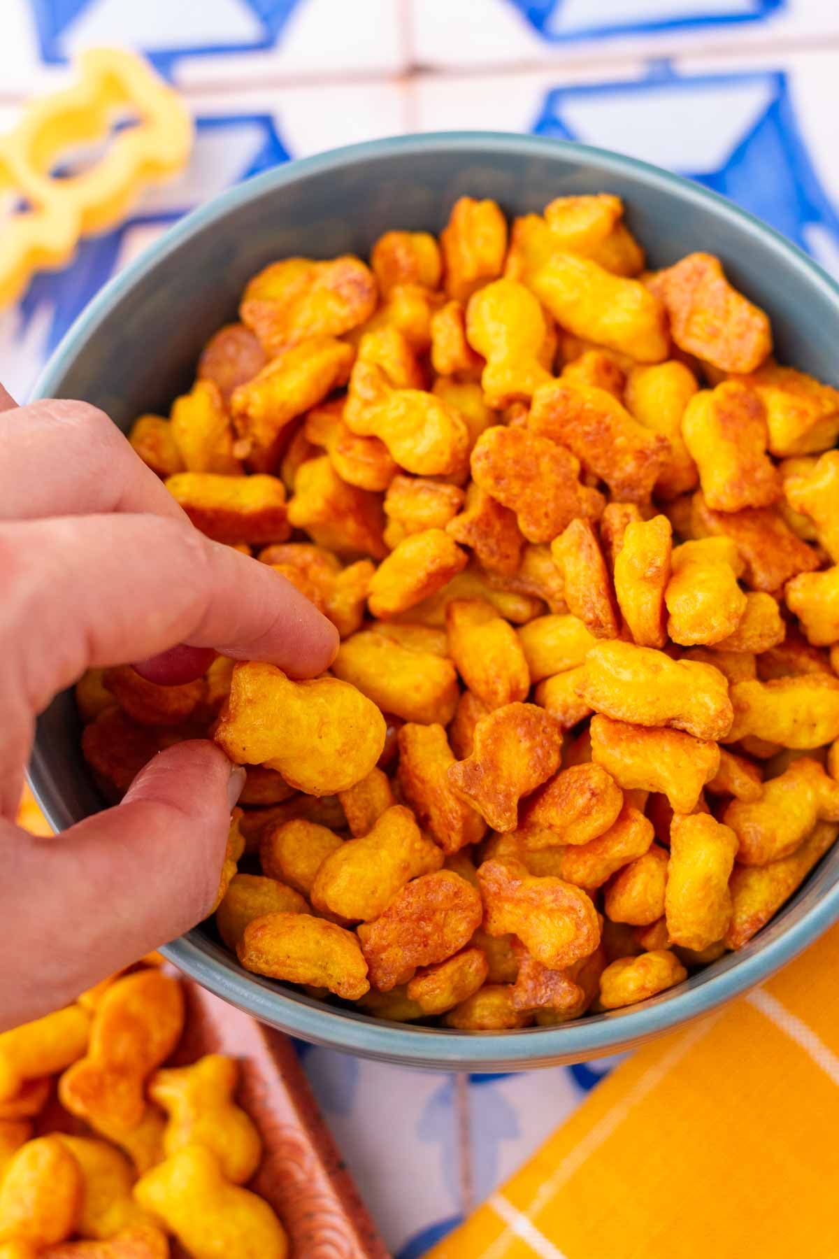 Hand picking up sourdough goldfish from a bowl.