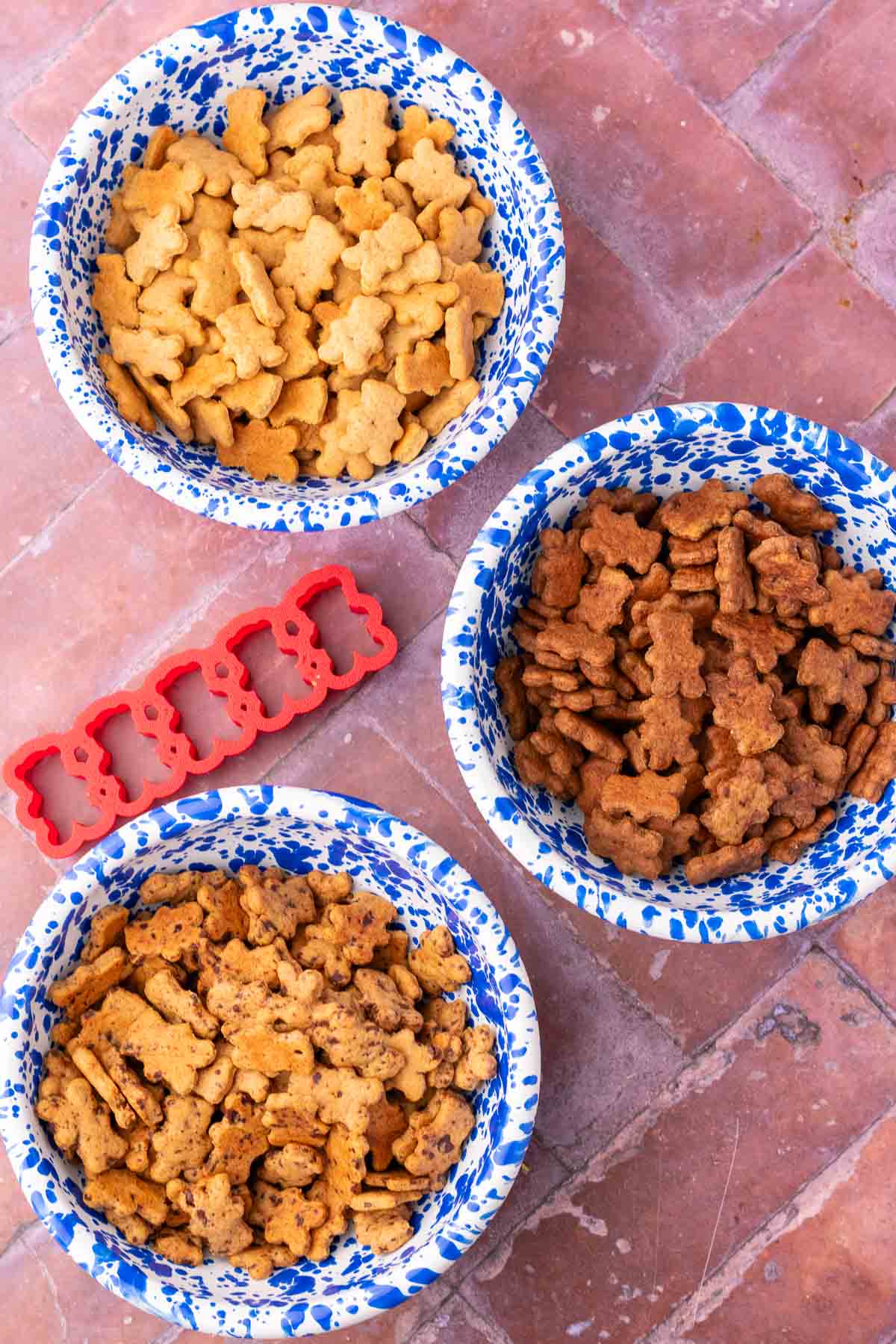 Three bowls of different flavors of sourdough teddy grahams including chocolate, chocolate chip, and cinnamon with bear cookie cut outs.