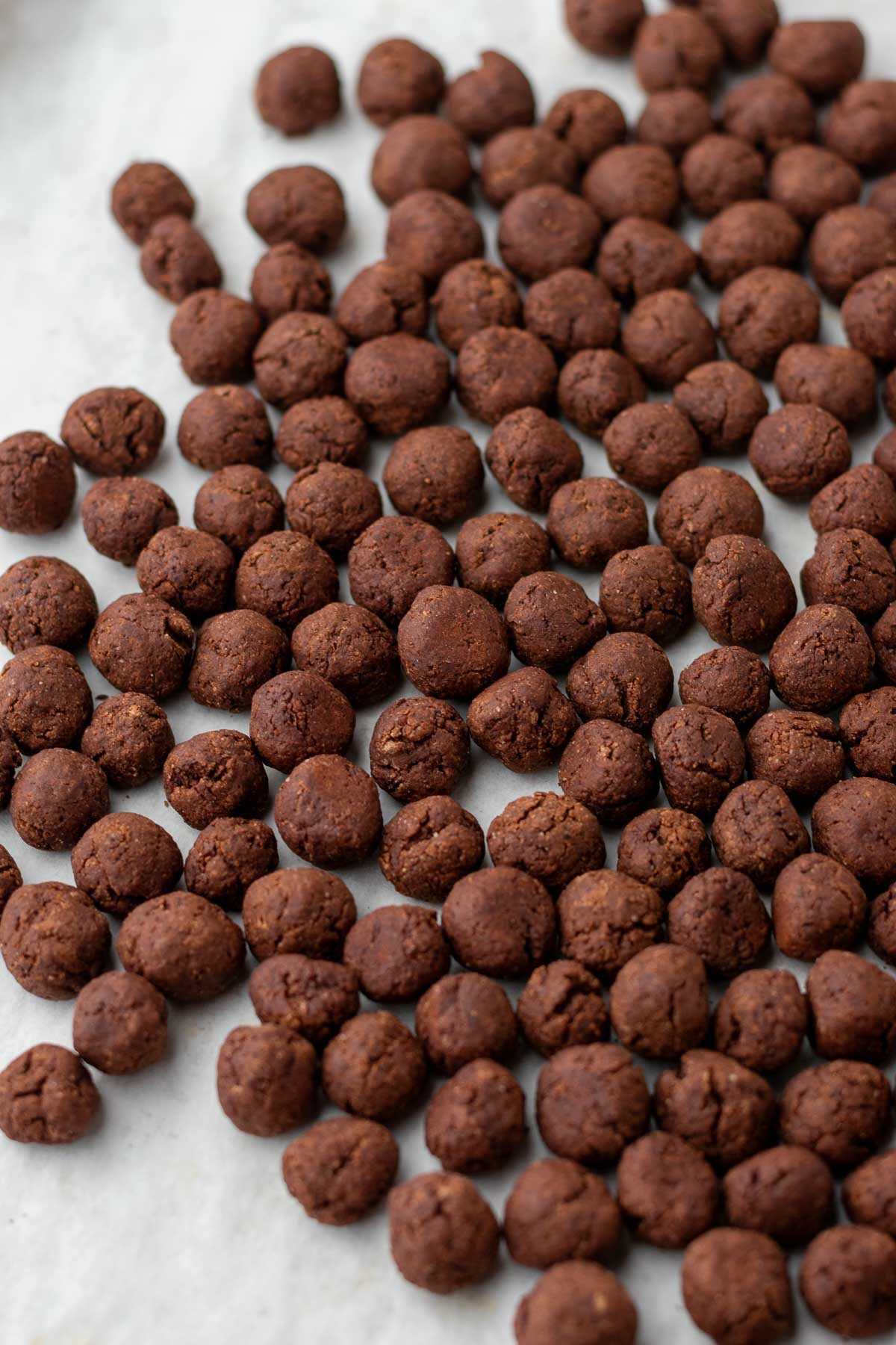 Baked sourdough cocoa puffs on a sheet pan with parchment paper.