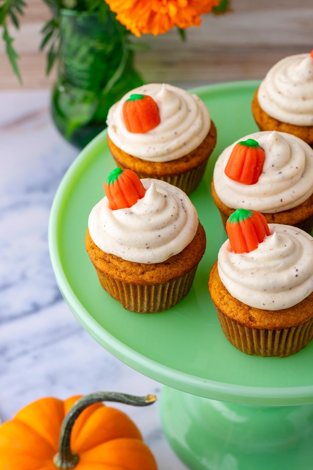 Sourdough pumpkin cupcakes on a green cake stand.