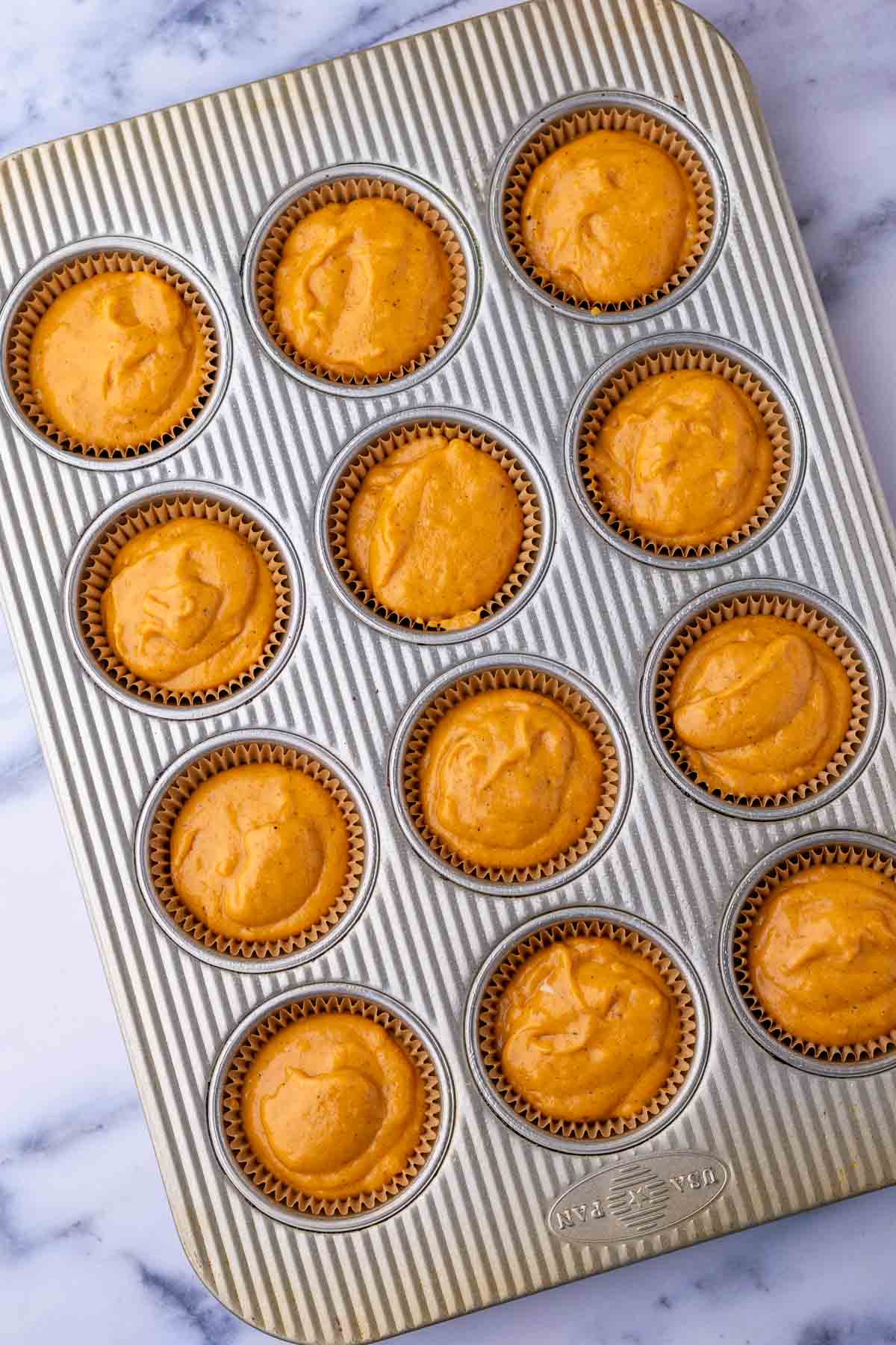 Unbaked sourdough pumpkin cupcakes in muffin pan.