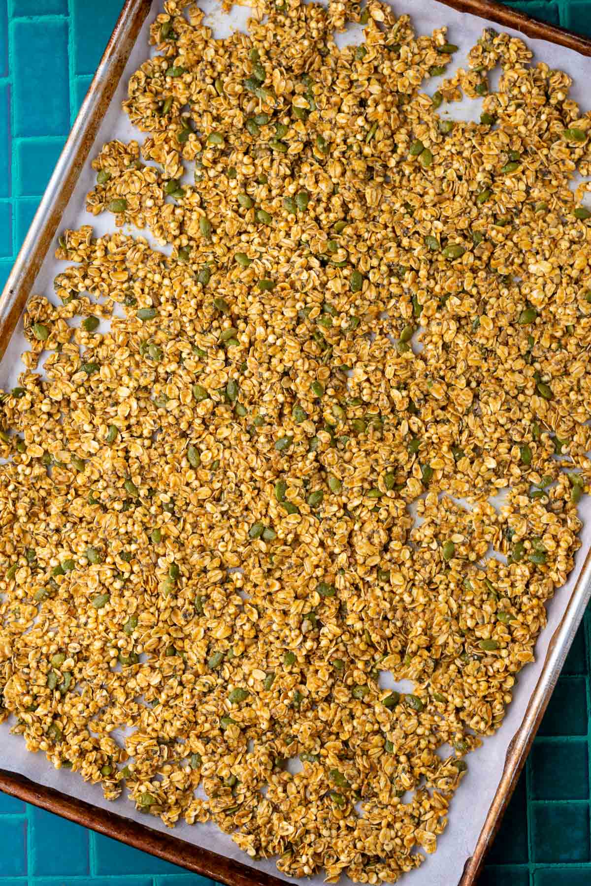 Unbaked sourdough pumpkin granola on a sheet pan.