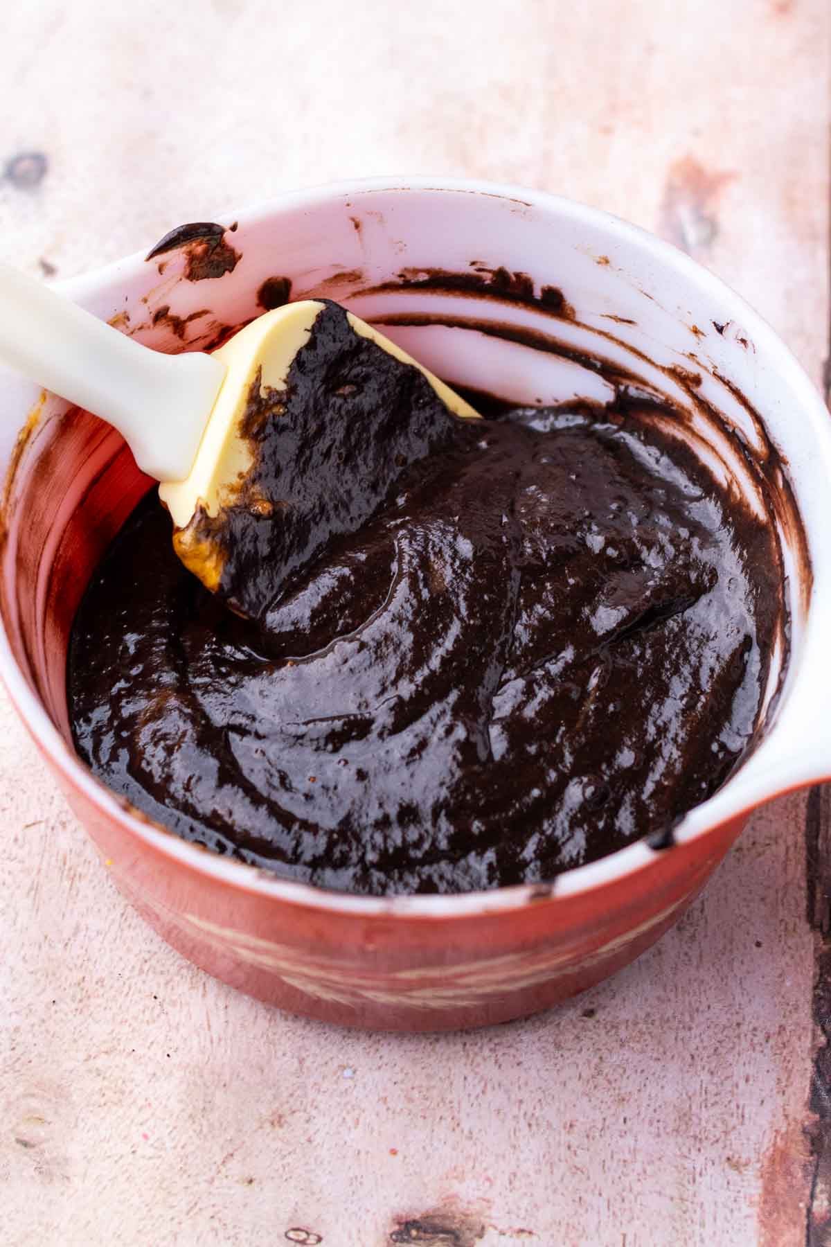 Mixed black cocoa batter for sourdough pumpkin marble bread in a bowl with a spatula.