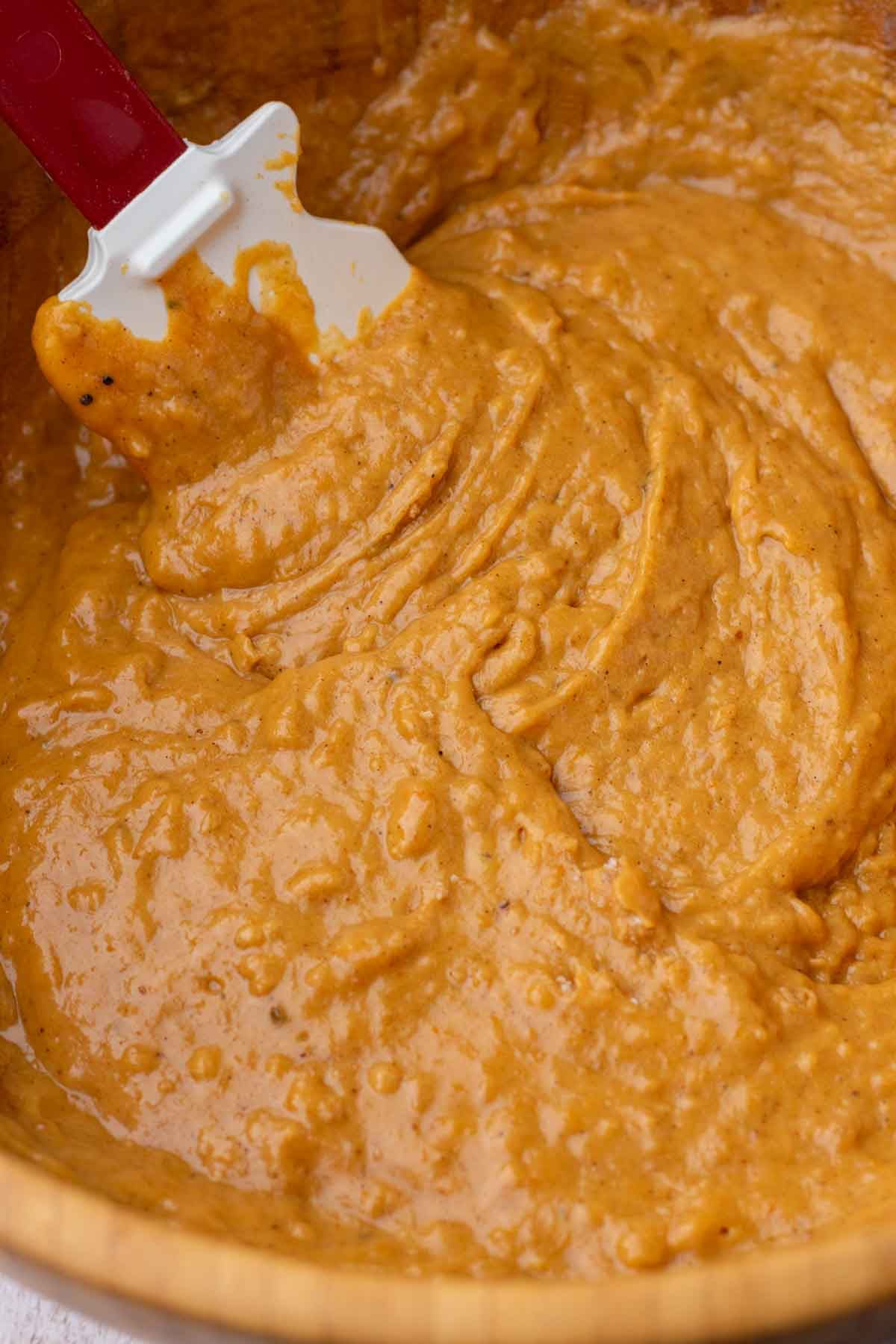 Mixed sourdough pumpkin marble bread batter in bowl with a spatula.